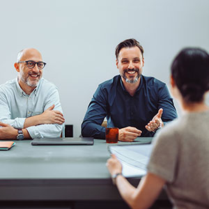 Gruppe in Seminarraum, eine Person pr&auml;sentiert &ndash; symbolisch f&uuml;r K&uuml;ndigung als Chance und beruflichen Neustart