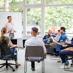 Gruppe von Teilnehmern in einem Seminarraum, eine Person pr&auml;sentiert &ndash; symbolisch f&uuml;r Umschulung ohne Schulabschluss