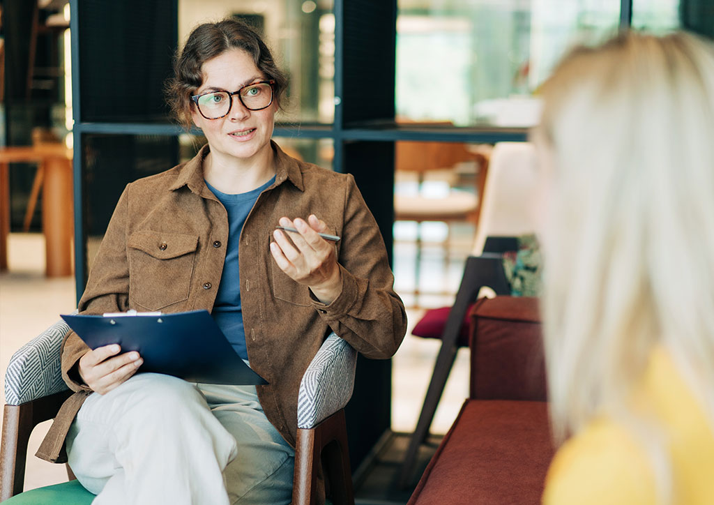 Bewerbungscoaching Fachkraft analysiert Unterlagen im pers&ouml;nlichen Gespr&auml;ch